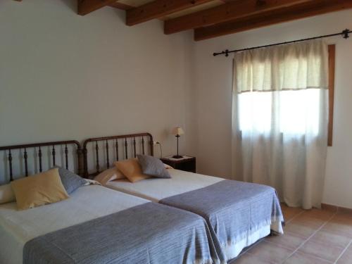 two beds in a bedroom with a window at Agroturismo Finca Son Sala in Campos
