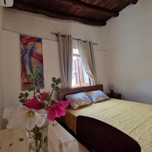 a bedroom with a bed with flowers on it at THE ROCK HOUSE - Beautiful countryside with mandarins oranges and olive trees,. Near Limassol at Eptagonia village. in Ephtagonia