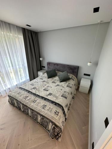 ein Schlafzimmer mit einem großen Bett in einem Zimmer in der Unterkunft Birutės parko apartamentai in Palanga