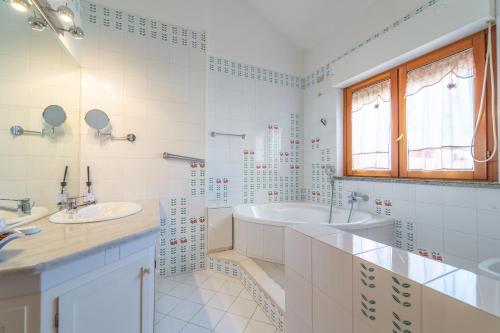 a white bathroom with two sinks and a tub at domo nora in Olbia