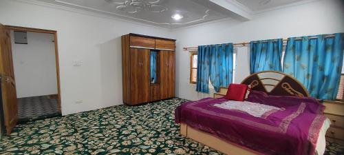 a bedroom with a bed and blue curtains at THE CLOVER Home Stay in Srinagar
