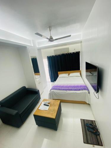 a bedroom with a bed and a table in it at Studio apartment nearby Dhaka airport in Dhaka