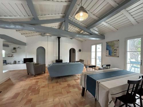 un grand salon avec une table et un canapé dans l'établissement Maison rénovée 2 chambres proche plage avec jardin clos et terrasse - Noirmoutier-en-l'Île - FR-1-224B-103, à Noirmoutier-en-l'lle