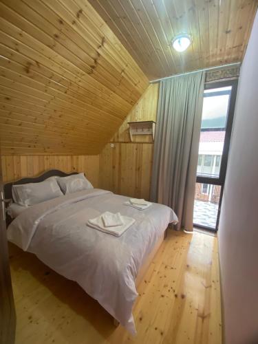 a bed in a wooden room with a large window at Kirta in Gordi