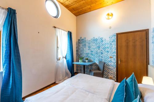 a bedroom with a bed and a window and a table at Sleep In Venzone in Venzone