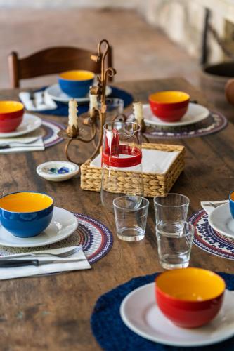 a wooden table with plates and bowls and glasses at Sleep In Venzone in Venzone