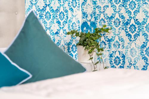 a plant in a vase in front of a blue wall at Sleep In Venzone in Venzone