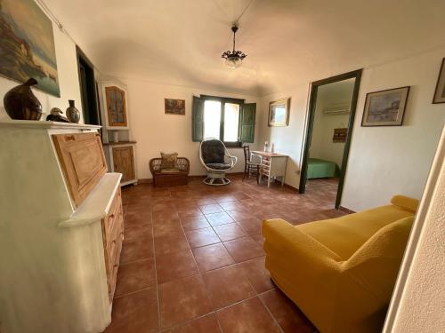 a living room with a yellow couch and a table at La Casa Del Borgo Cavallaro in Gaggi