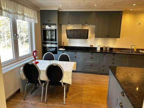 a kitchen with a table and chairs in a kitchen at Östavall Kölsillre Lyxvilla, fiber internet WiFi in Haverö