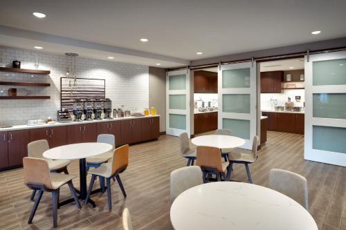 a restaurant with tables and chairs and a kitchen at Residence Inn by Marriott Provo South University in Provo