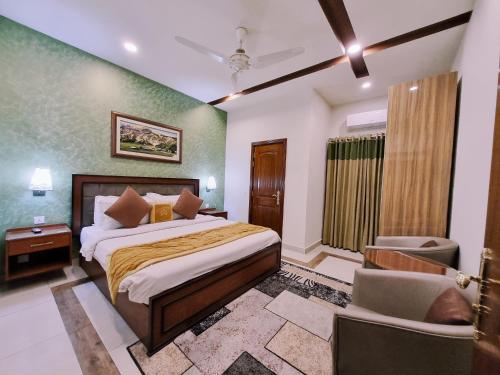 a bedroom with a bed and a chair in it at Hayyat Luxury Hotel Apartments in Lahore