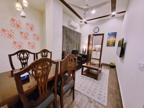 a living room with a table and chairs and a couch at Hayyat Luxury Hotel Apartments in Lahore