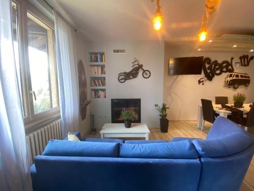een woonkamer met een blauwe bank en een tafel bij Hammer House in Porlezza