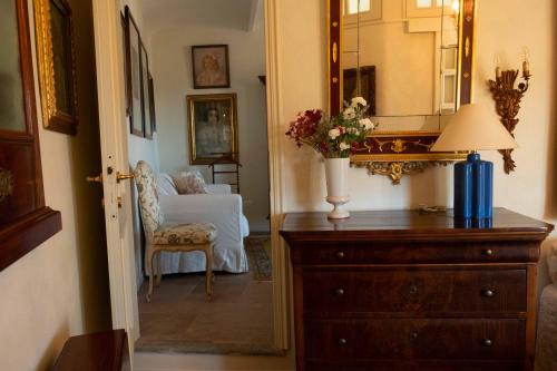 a room with a dresser and a chair and a mirror at Ai Leoni Ruggenti - Suite dei Tesori Antichi in Monferrato in Ottiglio