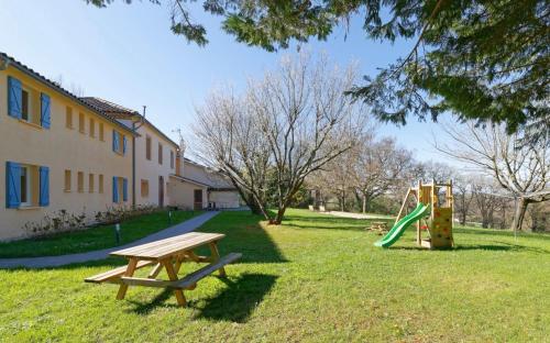 a park with a picnic table and a playground at Chalet de charme climatisé, son Jacuzzi - SPA privatif et la piscine de la Maison Bleue du Gers in Savignac-Mona