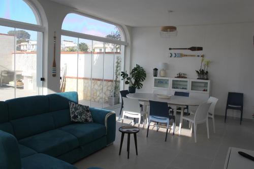 sala de estar con sofá, mesa y sillas en Isola Bianca, en Isola delle Femmine