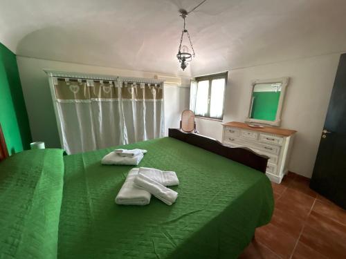 a bedroom with two towels on a green bed at La Casa Del Borgo Cavallaro in Gaggi
