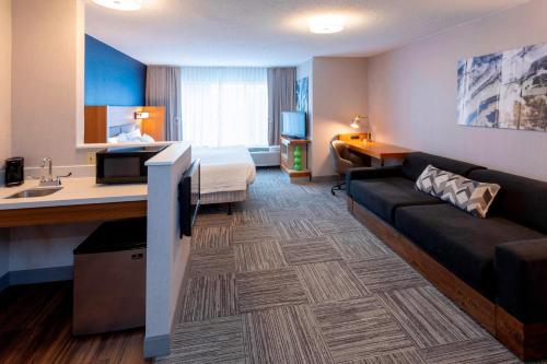 - une chambre d'hôtel avec un lit et un canapé dans l'établissement SpringHill Suites Rochester Mayo Clinic Area / Saint Marys, à Rochester