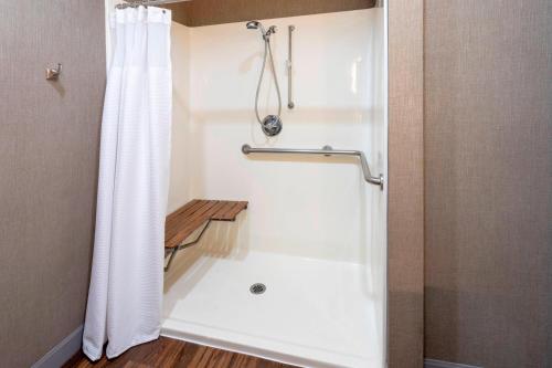 a bathroom with a shower with a white shower curtain at SpringHill Suites Rochester Mayo Clinic Area / Saint Marys in Rochester
