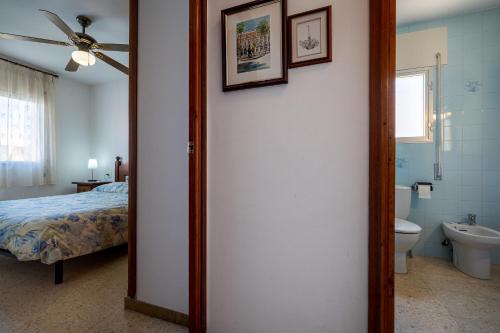 Un dormitorio con una cama y un baño con inodoro. en AT015 Piscina y aparcamiento, a 7 min de la playa La Paella, en Torredembarra