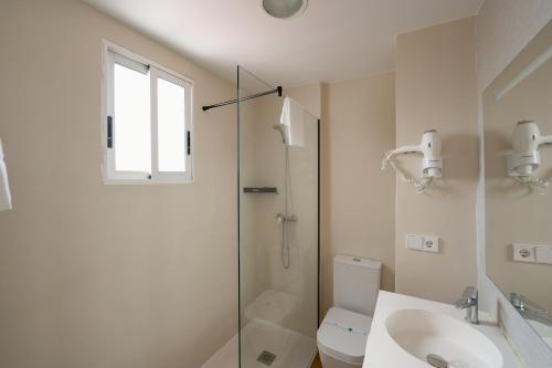 a bathroom with a shower and a toilet and a sink at Hotel Internacional in Benidorm