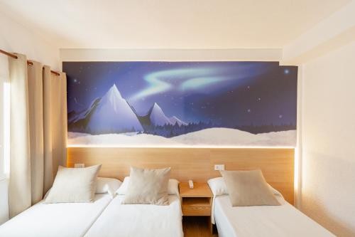 two beds in a room with a painting on the wall at Hotel Internacional in Benidorm
