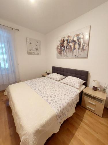 1 dormitorio con 1 cama y una pintura en la pared en Apartment Ana, en Split