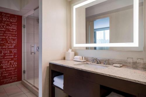 La salle de bains est pourvue d'un lavabo, d'un miroir et d'une douche. dans l'établissement Renaissance Baton Rouge Hotel, à Bâton-Rouge