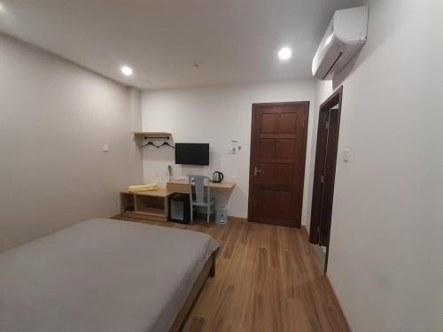 a bedroom with a bed and a desk with a computer at Happy Home in Nha Trang