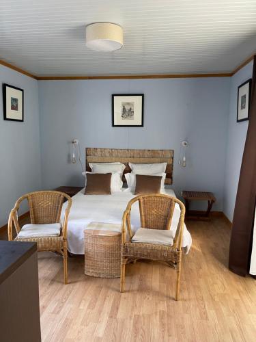 a bedroom with a large bed and two chairs at Quinta Dos Amarelos no Meco in Aldeia do Meco