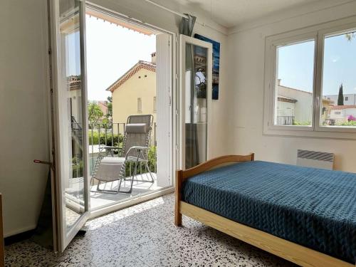 une chambre avec un lit et une grande fenêtre dans l'établissement Appartement Coquet à 300m de la Plage avec Garage et Balcon - Argelès-sur-Mer - FR-1-225-668, à Argelès-sur-Mer