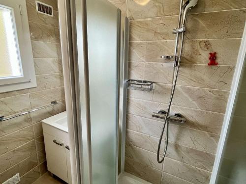 une douche avec une porte vitrée dans une salle de bain dans l'établissement Appartement Coquet à 300m de la Plage avec Garage et Balcon - Argelès-sur-Mer - FR-1-225-668, à Argelès-sur-Mer