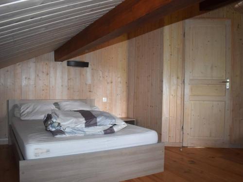 Bett in einem Zimmer mit einer Holzwand in der Unterkunft Chalet Font-Romeu-Odeillo-Via, 4 pièces, 8 personnes - FR-1-580-10 in Font Romeu Odeillo Via