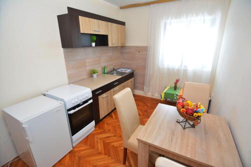 una pequeña cocina con mesa y nevera blanca en Apartments Radonjic en Budva