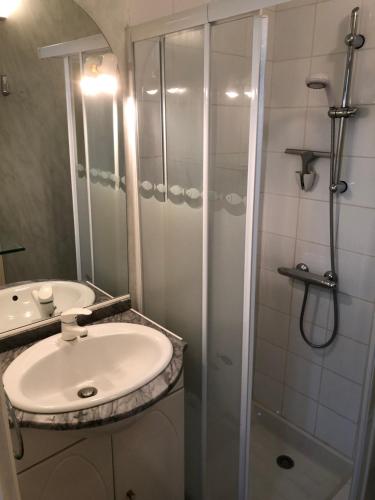 une salle de bain blanche avec une douche et un lavabo dans l'établissement Studio des îles, à Cavalaire-sur-Mer