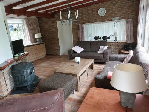 a living room with a couch and a stove at Ons Stekkie in Holten