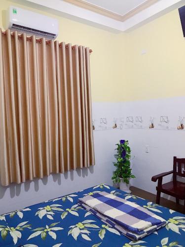 a bedroom with a bed and a window with curtains at Khách sạn Thanh Bình Bến Lức in Bến Lức