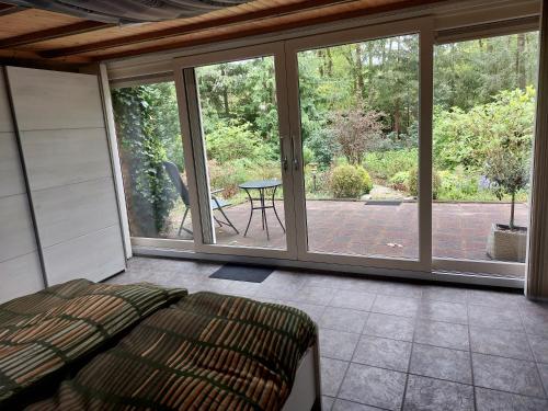 a bedroom with sliding glass doors and a table at Ons Stekkie in Holten