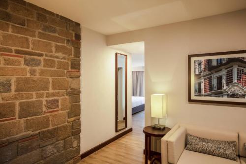 a living room with a couch and a brick wall at Marriott Puebla Hotel Meson del Angel in Puebla