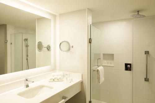 a white bathroom with a sink and a shower at Marriott Puebla Hotel Meson del Angel in Puebla
