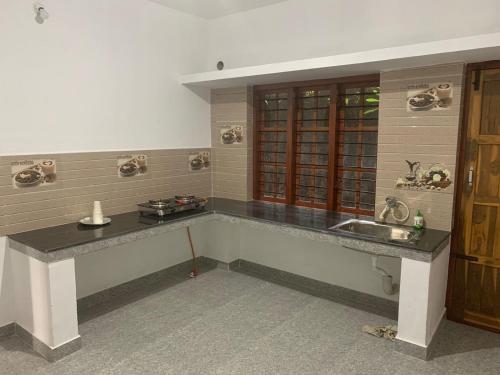 cocina con fregadero y encimera en Shivalaya Homestay, en Madikeri