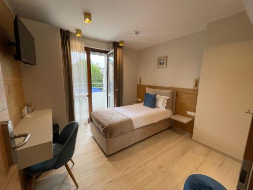 1 dormitorio con 1 cama y TV en una habitación en Albergo Aida, en Luxemburgo