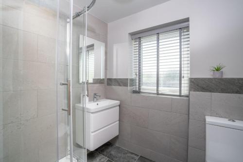 a bathroom with a shower and a toilet and a sink at Contemporary Home with Parking by LetMeStay in Kendal