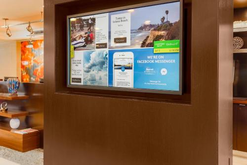 a flat screen tv on a wall in a room at Courtyard by Marriott San Diego Del Mar/Solana Beach in Solana Beach