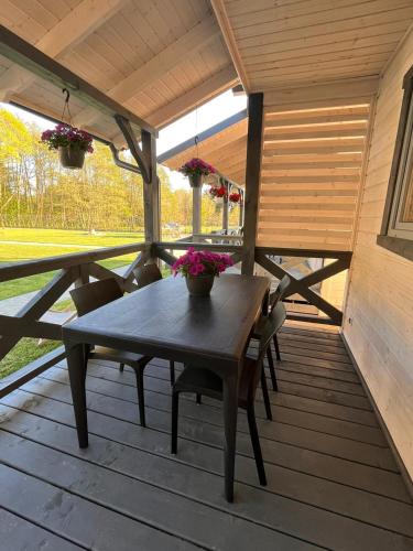 a wooden table and chairs on a porch at San Sebastian - domki nad morzem in Ustka