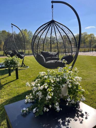 a swing yard with a basket of flowers at San Sebastian - domki nad morzem in Ustka