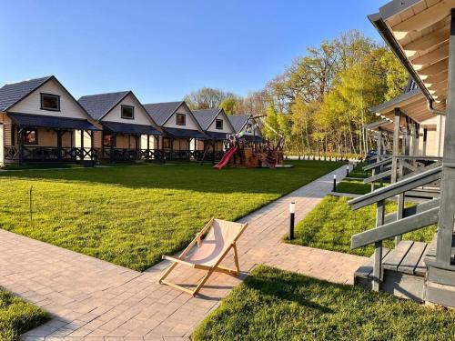 a house with a playground in the yard at San Sebastian - domki nad morzem in Ustka