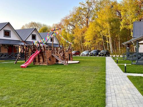 a playground with a slide in a yard at San Sebastian - domki nad morzem in Ustka