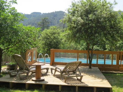 - une terrasse avec 2 chaises, une table et une piscine dans l'établissement Chez Cécile et Mickaël, à Saint-Fortunat-sur-Eyrieux