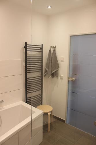 een badkamer met een bad en een glazen douchedeur bij Ferienwohnung Inga in Hasselfelde